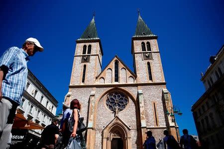 People walk past the Sacred Heart Cathedral in Sarajevo, Bosnia and Herzegovina, July 28, 2017. Supervising architect Josip Vancas modelled the 19th century cathedral after the Notre-Dame in Dijon, France. REUTERS/Dado Ruvic