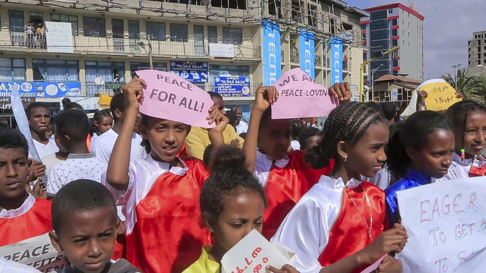 Children from a local martial arts and fitness center hold peace signs at a street carnival organized by the Tigray Development Association in support of the recent peace deal agreed between the Ethiopian federal government and Tigray forces, in Mekele, the capital of the Tigray region, in northern Ethiopia on Saturday, Nov. 26, 2022. (AP Photo)