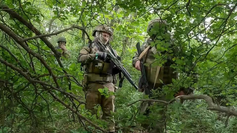 FILE - In this photo, taken from video released by the Russian Defense Ministry Press Service on Wednesday, June 12, 2024, Russian soldiers walk through a forest in an undisclosed location in Ukraine. Russia has taken advantage of its edge in firepower amid delays in U.S. aid to scale up attacks in several areas along the 1,000-kilometer (600-mile) front. (Russian Defense Ministry Press Service via AP, File)