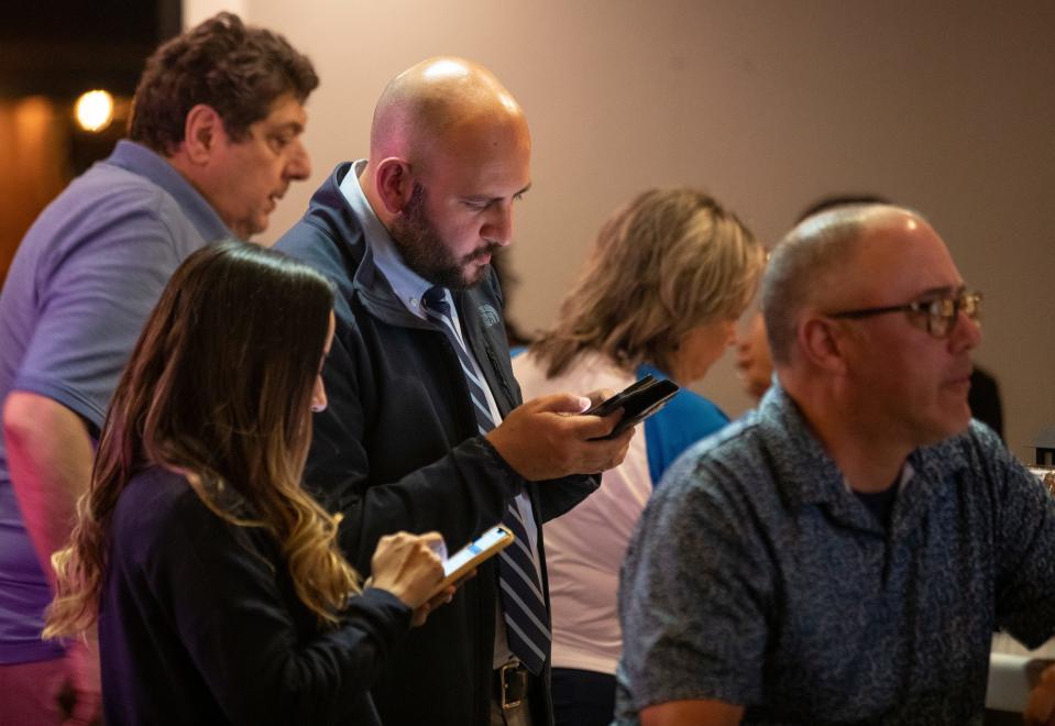 James Montoya checks election results on his phone at his watch party at Papa Doble in El Paso, TX on March 5, 2024.