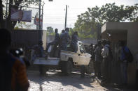 Police drive behind a vehicle carrying alleged gang leader Arnel Joseph from the courthouse to the National Penitentiary after he was brought before a judge for the first time since his July 2019 arrest, as members of the press film the caravan in Port-au-Prince, Haiti, Monday, Jan. 25, 2021. In mid-January, the U.N. met with USAID and Haitian authorities to relaunch certain initiatives and agree on ways to reboot the judicial system and limit the number of people taken into custody. (AP Photo/Dieu Nalio Chery)