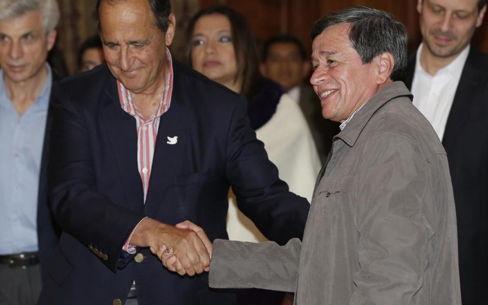 El representante del gobierno colombiano, Juan Camilo Restrepo, izquierda, y el representante de la guerrilla, Pablo Beltrán, del Ejército de Liberación Nacional (ELN), se estrechan la mano al final de una conferencia de prensa conjunta en Quito, Ecuador, el miércoles 18 de enero de 2017. El segundo grupo guerrillero más grande de Colombia ha accedido a liberar a un político prominente que ha mantenido cautivo casi un año, permitiendo que así avancen los diálogos el mes entrante. (AP Foto/Dolores Ochoa)