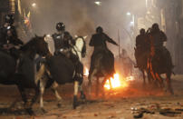 Mounted police advance on demonstrators protesting the president near the government palace in Quito, Ecuador, Thursday, Oct. 3, 2019. Ecuador's President Lenín Moreno has declared a state of emergency to confront street protests and a nationwide transport strike over his decision to end government fuel subsidies and relax labor protections. (AP Photo/Dolores Ochoa)