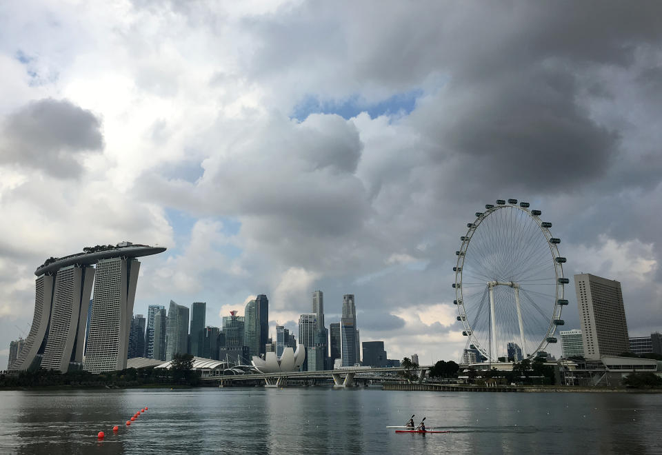 Two kayaks are dwarfed against the skyline of the Marina Bay area, which is home to popular hotels, and tourist attractions such as the Singapore Flyer. (AP Photo/Wong Maye-E)