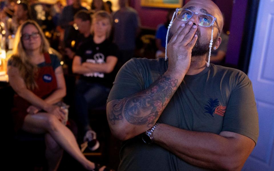 Jocardo Ralston, 47, from Pennsylvania, reacts as they look up to a television to watch the presidential debate between President Joe Biden and Republican presidential candidate former President Donald Trump at Tillie's Lounge on Thursday, June 27, 2024, in Cincinnati. "Biden has my vote because there is nothing at this point that Trump can say," said Ralston. For many voters in the U.S., there's despair in the air after the presidential debate this past week. (AP Photo/Carolyn Kaster)