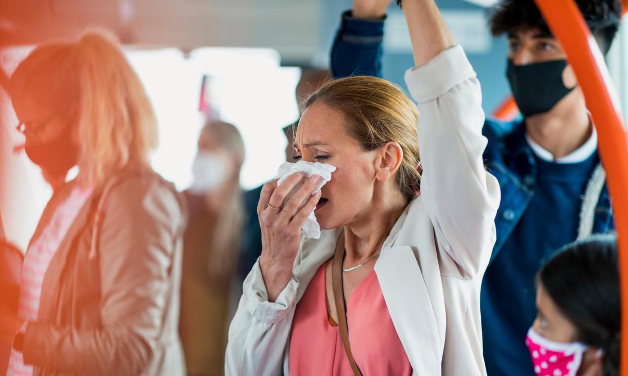<span>Experts advise those showing symptoms of Covid or flu to avoid contact with others, or wear a mask in public settings.</span><span>Photograph: SolStock/Getty Images</span>