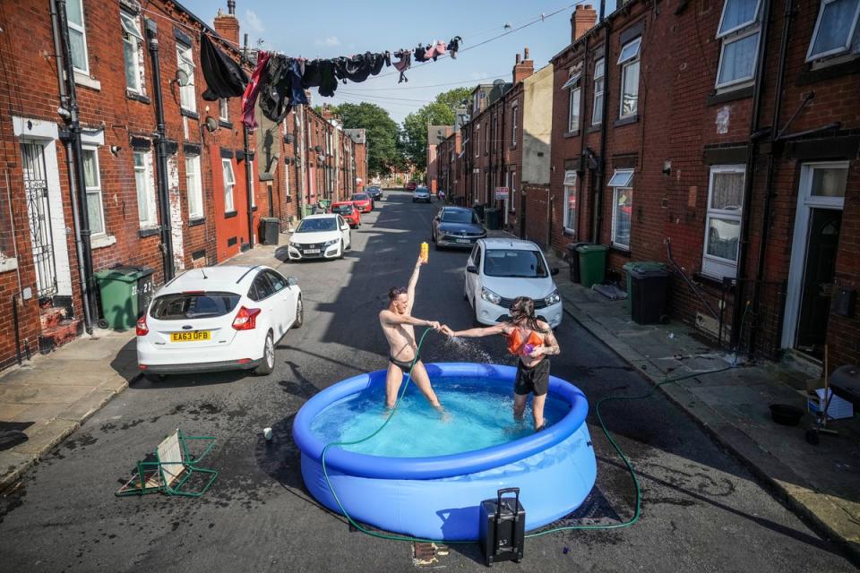 Residents take a dip in a paddling pool to cool off outside their home in Leeds during a heatwave across the UK (Getty)