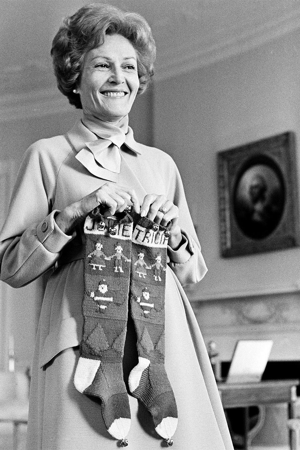 Patricia Nixon holds up stockings for daughters Julie and Tricia, December 1969.