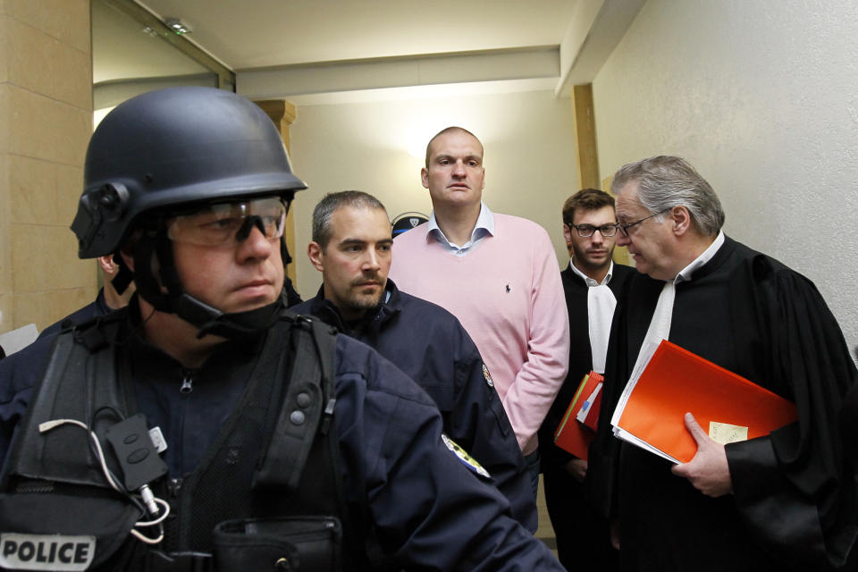 FILE - In this Thursday, May. 30, 2013 file photo, Marc Bertoldi, center, accused of masterminding a $US 50 million dollar diamond theft at Brussels Airport arrives under heavy security with his lawyers Olivier Rondu, 2nd right, and Dominique Rondu, right, at the court house in Metz, eastern France, prior to his extradition hearing. In a carefully planned 2013 heist, thieves cut through a fence at the Brussels airport, drove to a Switzerland-bound plane and snatched an estimated $50 million in diamonds. A brazen burglary on Monday Nov. 25, 2019 from Dresden’s Green Vault, one of the world’s oldest museums, holding priceless treasures is another in a long history of daring European heists over the years. (AP Photo/Mathieu Cugnot, File)