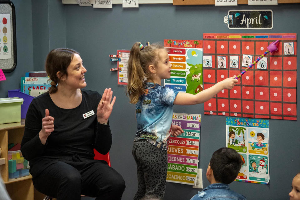 Sasha Mayorova, 5, performs a learning exercise under the watchful eye of assistant teacher Tess Tomlinson in April at the MetroWest YMCA in Framingham.