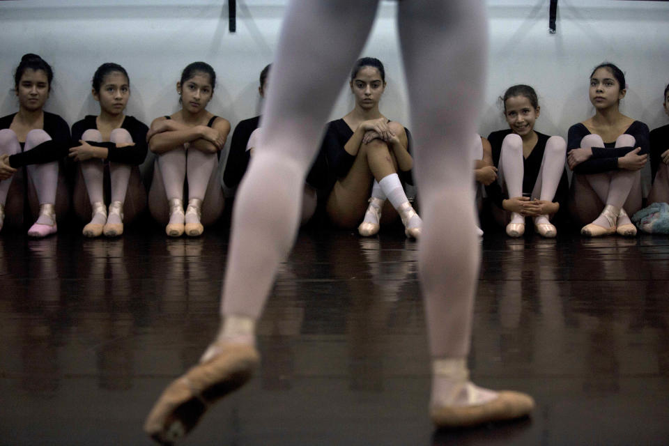 In this Aug. 28, 2012 photo, ballet dancers watch a classmate as they practice for a competition between ballet schools at the National Superior Ballet School in Lima, Peru. Nearly 100 girls and boys from Colombia, Venezuela, Chile, France and Peru are submitting themselves to a week-long competition hoping to win medals from Peru's national ballet school _ and perhaps a grant to study in Miami. (AP Photo/Martin Mejia)