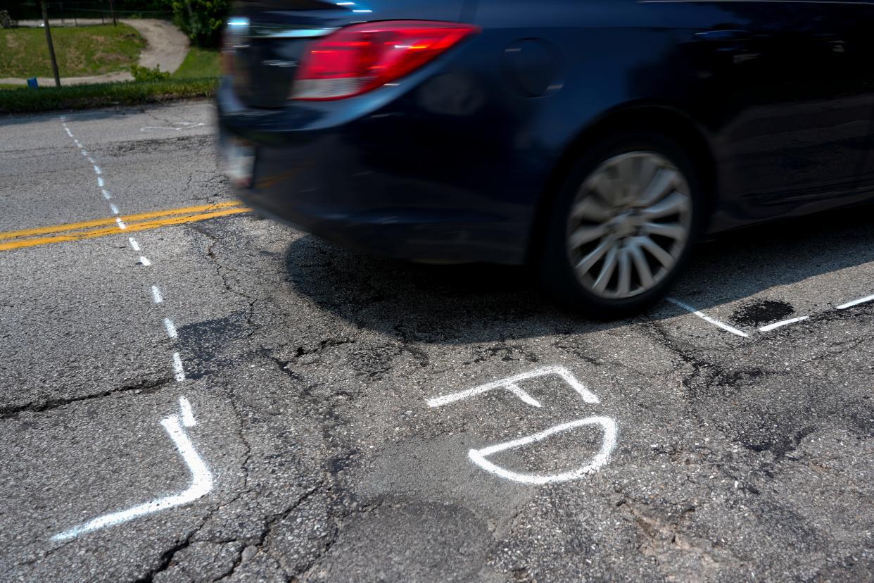 Vehicles travel northbound on Fairbanks Avenue in the Cincinnati neighborhood of Sedamsville over crumbling pavement marked for repair in the Sedamsville neighborhood of Cincinnati.