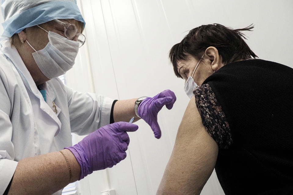 A Russian medical worker administers a shot of Russia's Sputnik V coronavirus vaccine to 75-year-old Maria Piparinen in a local rural medical post in the village of Ikhala in Russia’s Karelia region, Tuesday, Feb. 16, 2021. Piparinen and other elderly residents were relieved when they heard that doctors were finally bringing a few doses of the coronavirus vaccine to their remote, snowy village. (AP Photo/Dmitri Lovetsky)