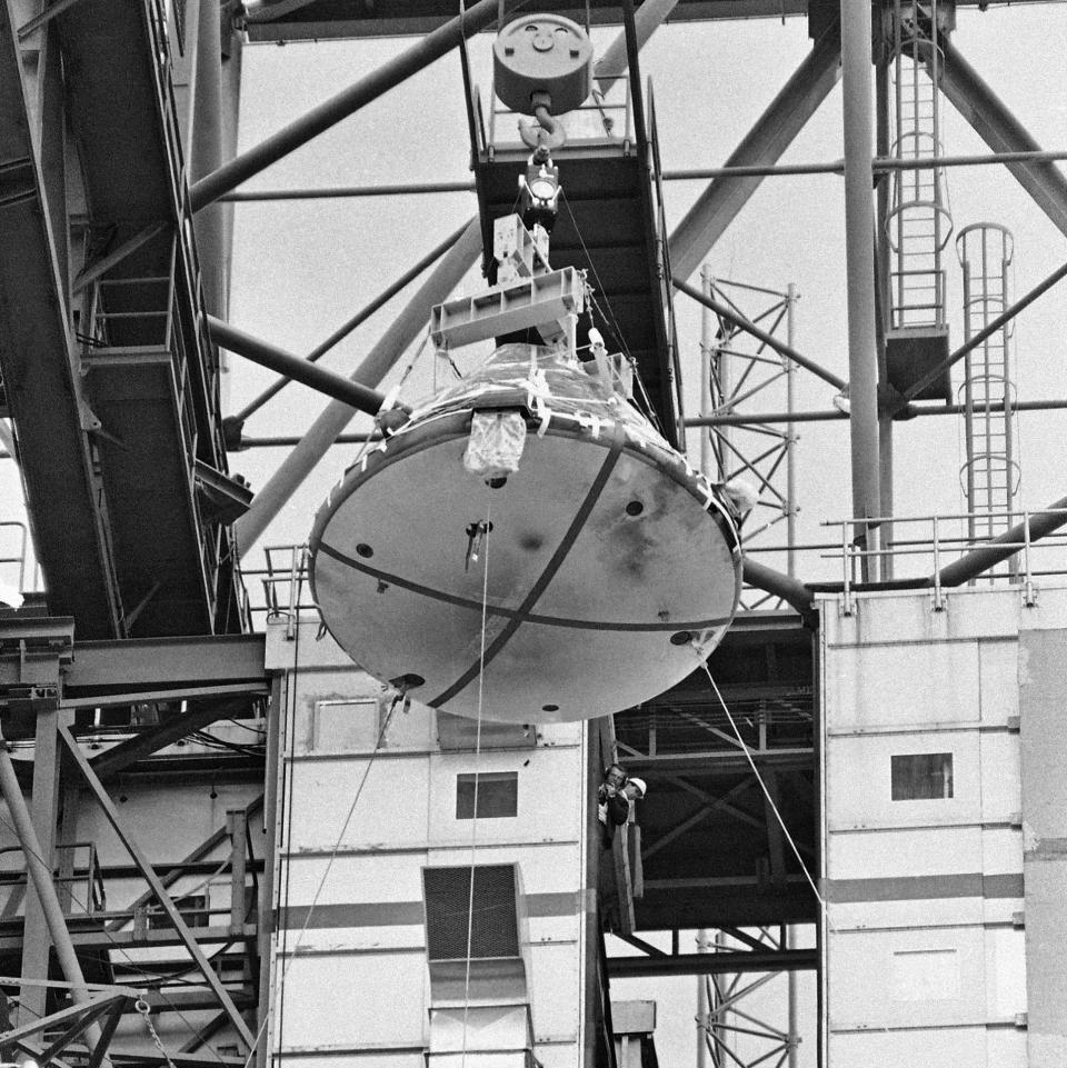 FILE - In this Feb. 17, 1967 file photo, the Apollo 1 capsule, with black smudge marks visible on the heat shield, is lowered from its Saturn 1 booster at Cape Kennedy, Fla. During a launch pad test on Jan. 27, 1967, a flash fire erupted inside the craft killing the three Apollo crew members aboard. (AP Photo/Jim Kerlin, Pool)