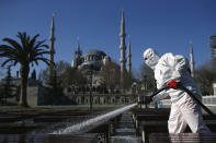 FILE - In this Saturday, March 21, 2020, file photo, a municipality worker wearing a face mask and protective suit disinfects the area outside the historical Sultan Ahmed Mosque, also known as Blue Mosque, amid the coronavirus outbreak, in Istanbul. When Turkey changed the way it reports daily COVID-19 infections, it confirmed what medical groups and opposition parties have long suspected — that the country is faced with an alarming surge of cases that is fast exhausting the Turkish health system. The official daily COVID-19 deaths have also steadily risen to record numbers in a reversal of fortune for the country that had been praised for managing to keep fatalities low. With the new data, the country jumped from being one of the least-affected countries in Europe to one of the worst-hit.(AP Photo/Emrah Gurel, File)