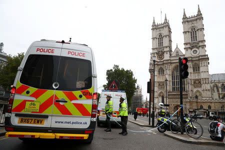 Police officers stand at a cordon after a car crashed outside the Houses of Parliament in Westminster, London, Britain, August 14, 2018. REUTERS/Hannah McKay