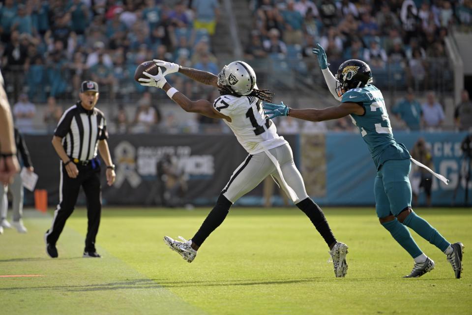 Las Vegas Raiders wide receiver Davante Adams (17) caches a pass in front of Jacksonville Jaguars cornerback Tyson Campbell (32) in the second half of an NFL football game Sunday, Nov. 6, 2022, in Jacksonville, Fla. (AP Photo/Phelan M. Ebenhack)