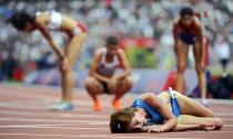Ukrainian runner Valentyna Horpynych Zhudina (foreground) and fellow competitors are exhausted after the women's 3000m Steeplechase heats at the London 2012 Olympic Games Athletics, Track and Field events at the Olympic Stadium, London, Britain, 04 August 2012. EPA/JOHN MABANGLO