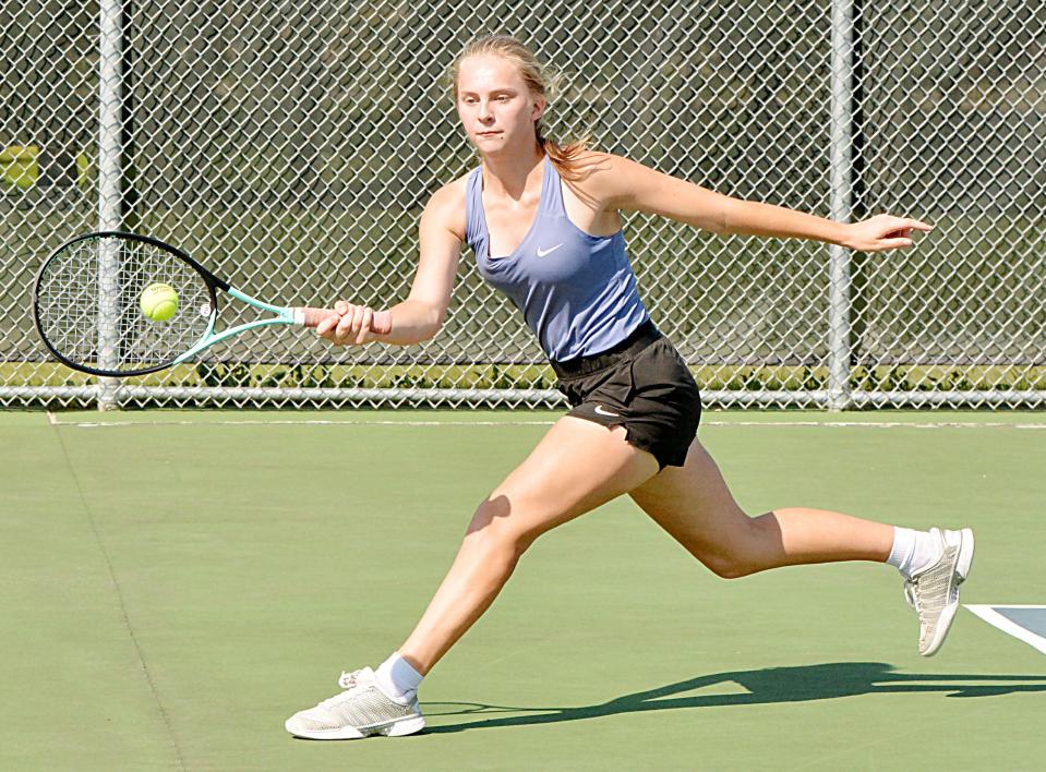 Watertown's Faith Berg goes outside the court to make a return shot during Tuesday's high school girls tennis dual against Milbank at the Highland Park Courts. The Arrows won 9-0.