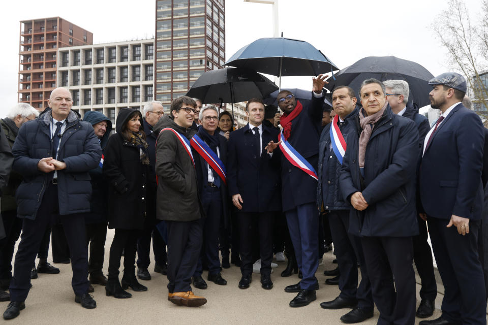 El presidente de Francia Emmanuel Macron, rodeado por funcionarios, participa de la ceremonia de inauguración de la Villa Olímpica, el jueves 29 de febrero de 2024, en Saint-Denis, al norte de París. (Ludovic Marin, Pool vía AP)