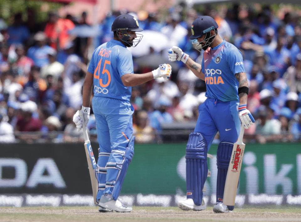 India's Rohit Sharma, left, bumps fist with Virat Kohli, right, during the first Twenty20 international cricket match against the West Indies, Saturday, Aug. 3, 2019, in Lauderhill, Fla. India won by four wickets. (AP Photo/Lynne Sladky)