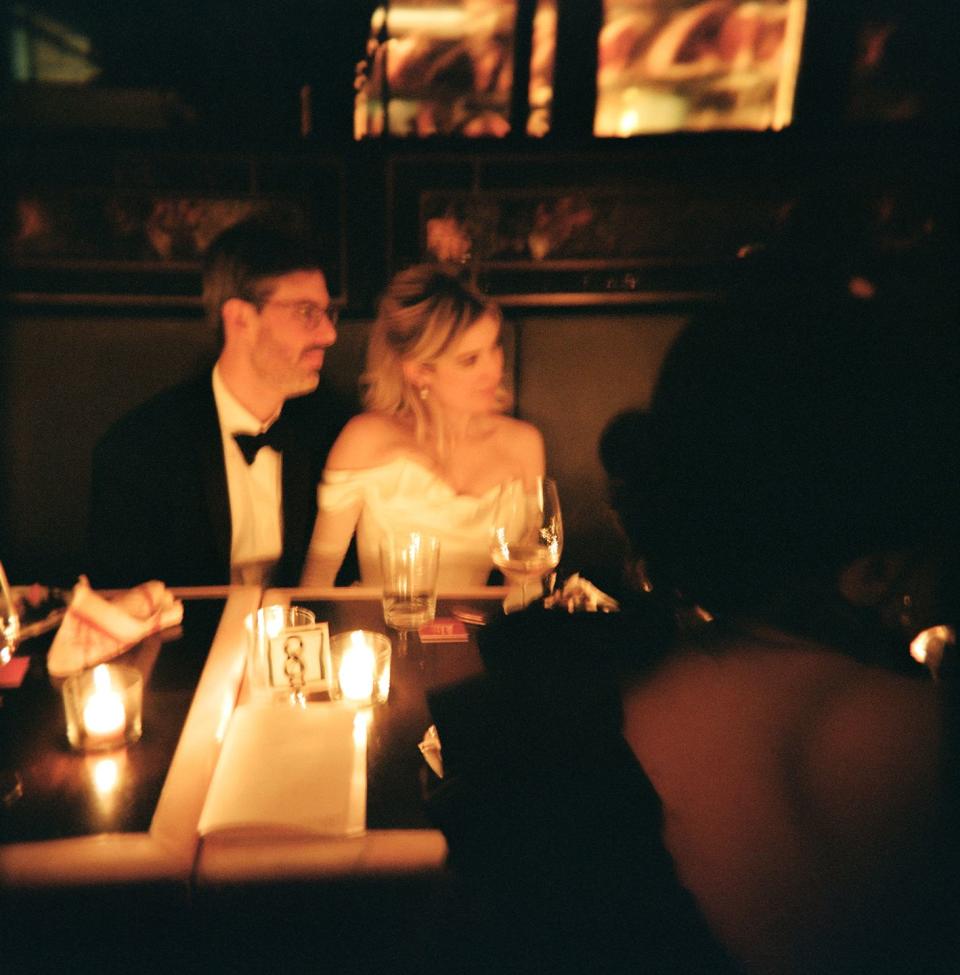 a man and woman sitting at a table with wine glasses