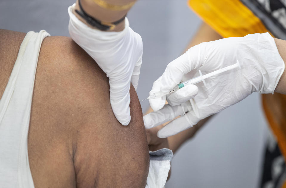 A health worker administers COVISHIELD vaccine to an elderly man at the Guwahati Medical College hospital in Gauhati, India, Monday, March 1, 2021. India is expanding its COVID-19 vaccination drive beyond health care and front-line workers, offering the shots to older people and those with medical conditions that put them at risk. (AP Photo/Anupam Nath)