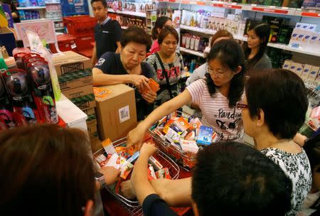 People shop for remaining stocks of insect repellent products at a pharmacy in Singapore September 2, 2016. REUTERS/Edgar Su