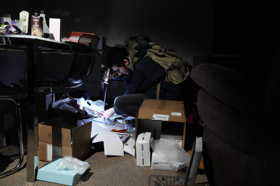 Jarod Valentin sorts through his belongings after an earthquake in Rio Dell, Calif., Tuesday, Dec. 20, 2022. (AP Photo/Godofredo A. Vásquez)