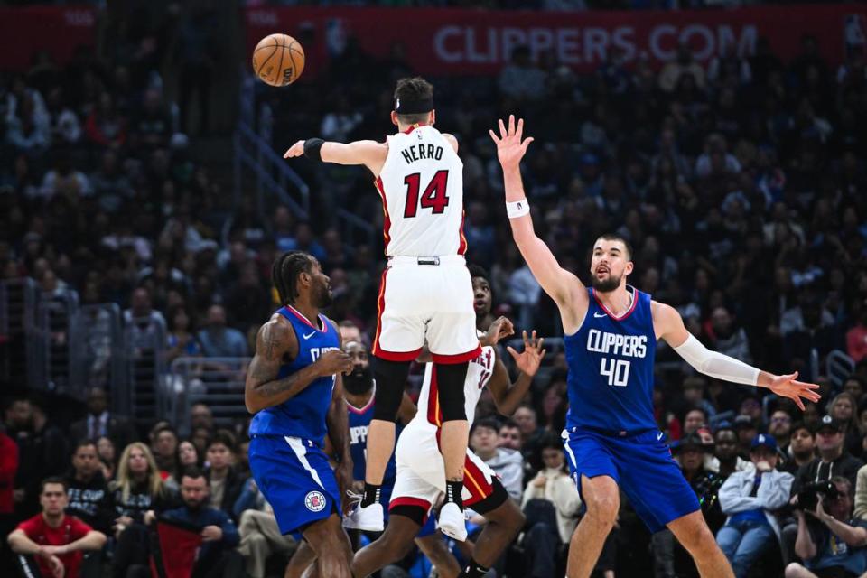 El jugador del Heat de Miami Tyler Herro pasa la pelota ante la marca de Kawhi Leonard (izq.) y Ivica Zubac, de los Clippers, en el partido celebrado el 1ro de enero de 2024 en Los Angeles.