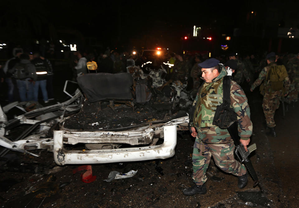 Lebanese army solider's stand guard near damages after a suicide bomber blew himself up in a passenger van in the Choueifat district southern Beirut, Lebanon, Monday, Feb. 3, 2014. A suicide bomber blew himself up in the southern suburbs of the Lebanese capital Monday, wounding at least six people, the state news agency said. The blast, which took place during the evening rush hour in the Choueifat district, appeared to be the latest of a string of attacks in Lebanon linked to the civil war in neighboring Syria. The conflict has deeply divided Lebanon along sectarian lines and helped fuel a surge in violence that has rattled the already fragile country. (AP Photo/Bilal Hussein)