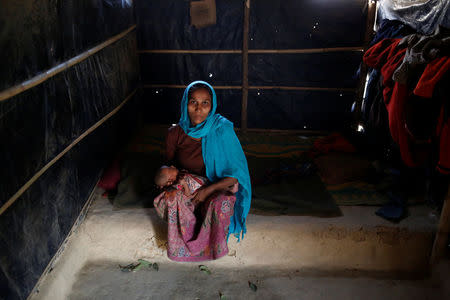 Ramida Begum, 35, holds her 10-day-old unnamed daughter as she poses for a photograph inside their shelter in Kutupalang unregistered refugee camp in Cox’s Bazar, Bangladesh, February 10, 2017. REUTERS/Mohammad Ponir Hossain