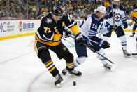 Pittsburgh Penguins' Evgeni Malkin (71) controls the puck with Winnipeg Jets' Mark Scheifele (55) defending during the second period of an NHL hockey game in Pittsburgh, Sunday, Jan. 23, 2022. (AP Photo/Gene J. Puskar)