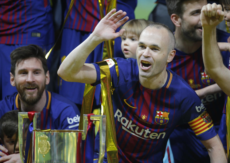 FC Barcelona’s Andres Iniesta, right, and Lionel Messi celebrate during an award ceremony after defeating Sevilla 5-0 in the Copa del Rey final soccer match at the Wanda Metropolitano stadium in Madrid, Spain, Saturday, April 21, 2018. (AP Photo/Paul White)