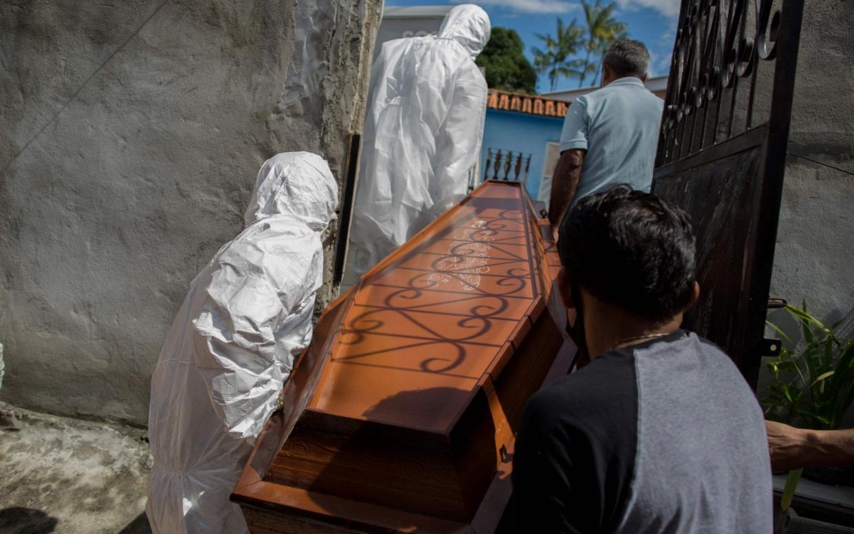 Burial workers remove the body of a man who died from Covid in Manaus, Brazil which has been hit hard by a second wave of Covid - Michael Dantas/AFP