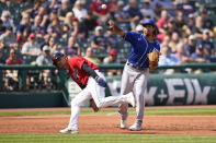 Kansas City Royals' Adalberto Mondesi, right, throws out Cleveland Indians' Myles Straw at first base as Andres Gimenez runs by in the second inning of a baseball game, Monday, Sept. 27, 2021, in Cleveland. (AP Photo/Tony Dejak)