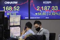 A currency trader wearing a mask watches a calendar at the foreign exchange dealing room of the KEB Hana Bank headquarters in Seoul, South Korea, Tuesday, Jan. 28, 2020. Asian shares continued to fall Tuesday, dragged down by worries about an outbreak of a new virus in China that threatens global economic growth. (AP Photo/Ahn Young-joon)