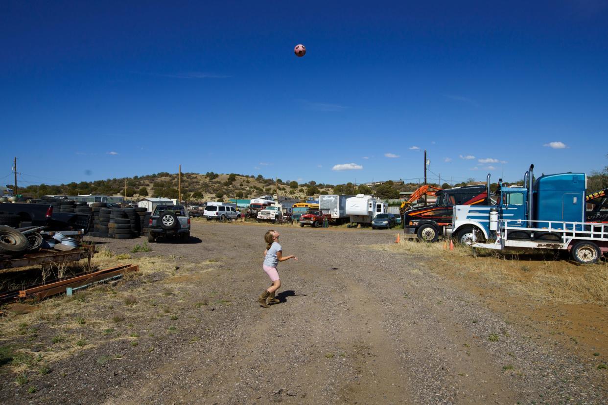 M kicks a soccer ball at home in Silver City, where the family runs a towing business.