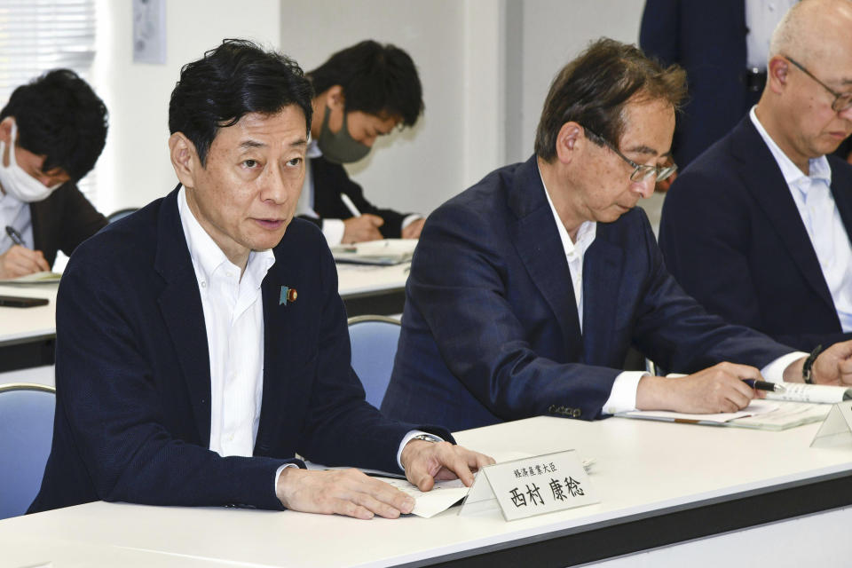 Japan's Industry Minister Yasutoshi Nishimura, left, meets with fisheries officials, not in photo, in Iwaki, Fukushima prefecture, northern Japan, Saturday, June 10, 2023. The operator of the wrecked Fukushima nuclear plant began tests on Monday of newly constructed facilities for discharging treated radioactive wastewater into the sea, a plan strongly opposed by local fishing communities and neighboring countries. Fisheries officials said they remain opposed to plan when they met Industry Minister Nishimura on Saturday when he visited Fukushima and the neighboring prefectures of Ibaraki and Miyagi.(Kyodo News via AP)