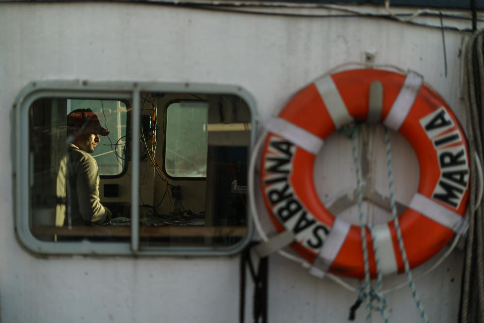 Anthony Lucia, with New England Maritime Monitoring, installs a camera on the Sabrina Marina fishing vessel in Gloucester, Mass., Wednesday, May 11, 2022. A bevy of companies is installing high-resolution cameras on U.S. fishing boats to replace scarce in-person observers and meet new federal mandates aimed at protecting dwindling fish stocks. But taking the technology beyond U.S. waters, where the vast majority of seafood consumed in the U.S. is caught, is a steep challenge. (AP Photo/David Goldman)