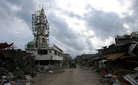 A military truck drives past damaged buildings and a mosque after government troops cleared the area from pro-Islamic State militant groups inside a war-torn area in Bangolo town, Marawi City, southern Philippines October 23, 2017. REUTERS/Romeo Ranoco