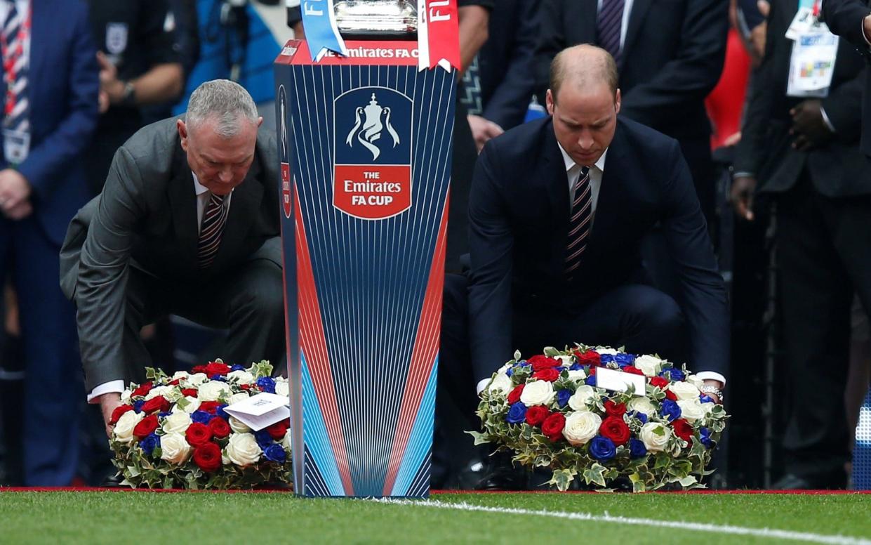 Prince William (right) and Greg Clarke lay wreaths to the Manchester bombing victims - REUTERS