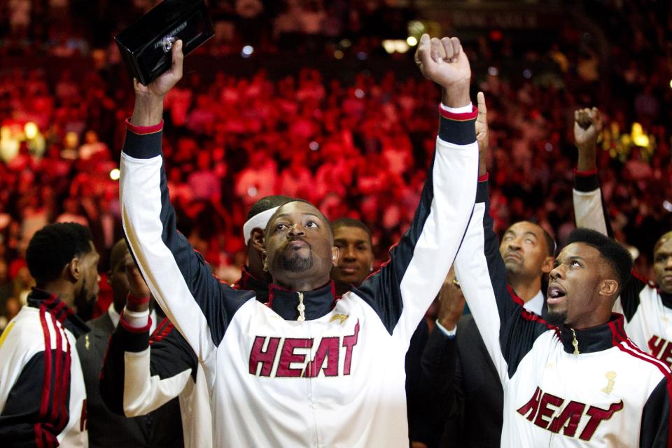 Miami Heat's Dwyane Wade holds his 2012 NBA Finals championship ring during a ceremony before a basketball game against the Boston Celtics, Tuesday, Oct. 30, 2012, in Miami. (AP Photo/J Pat Carter)