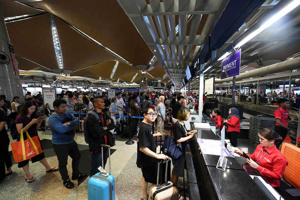Passengers check in for their flights at KLIA in Sepang August 23, 2019. — Bernama pic