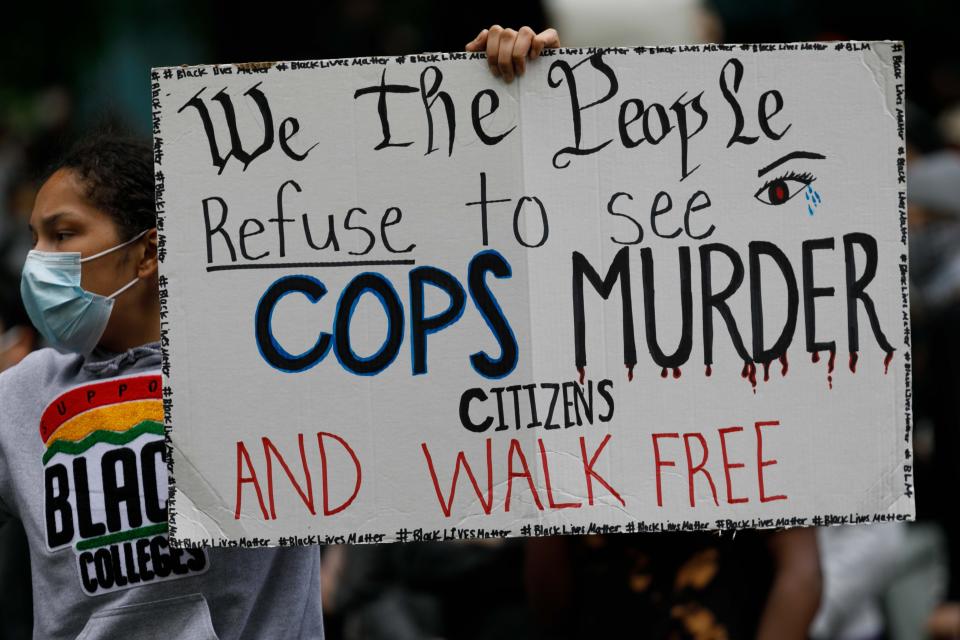 <i>People carry a banner that says "We the people refuse to see cops murder citizens and walk free" as they march to protest the death of George Floyd on May 31 in Portland, Oregon.</i>