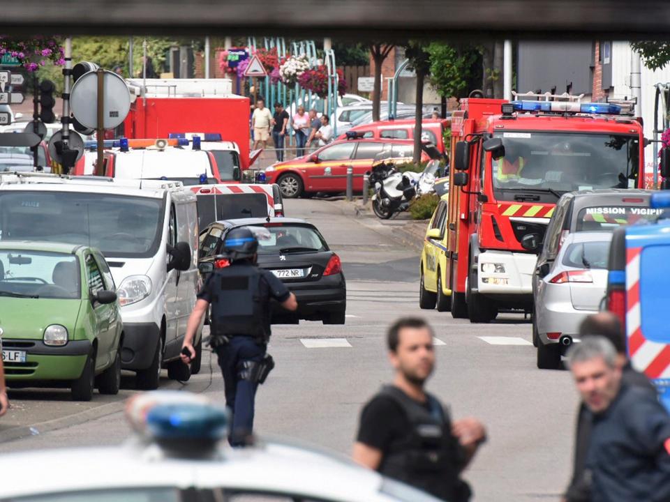 Police and rescue workers stand at the scene after two assailants had taken five people hostage in the church at Saint-Etienne-du -Rouvray near Rouen in Normandy, France, July 26, 2016.