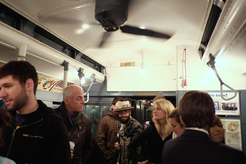 NEW YORK, NY - DECEMBER 16: People walk through a vintage New York City subway car as it moves along the M line on December 16, 2012 in New York City. The New York Metropolitan Transportation Authority (MTA) runs vintage subway trains from the 1930's-1970's each Sunday along the M train route from Manhattan to Queens through the first of the year. (Photo by Preston Rescigno/Getty Images)