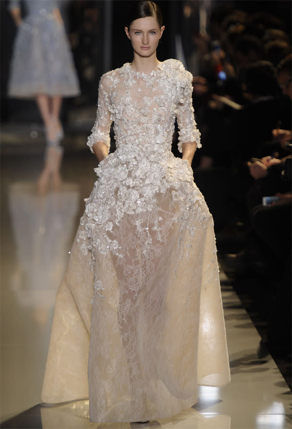 <b>Elie Saab SS13 </b><br><br>Soft detailing on the bodice flowing into a lace floor-length skirt with subtle pattern.<br><br>©Rex