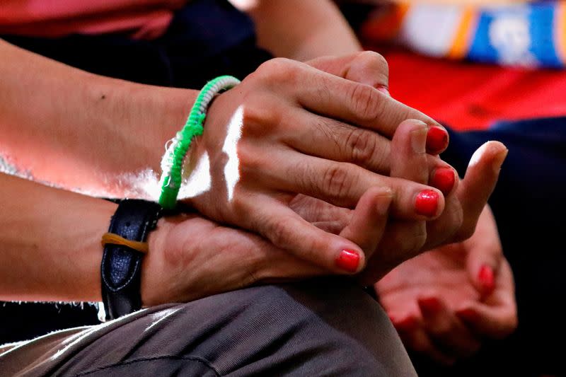Chika, a 28-year-old trans woman who works as a busker holds her boyfriend's hand during an interview at their rented room in Jakarta