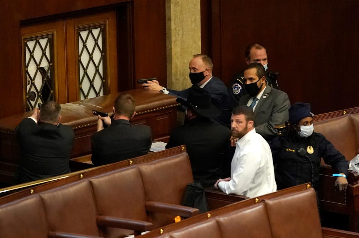 U.S. Capitol police officers point their guns at a door that was vandalized in the House of Representatives on Jan. 6, 2021, in the aftermath of the last American presidential election.  (Drew Angerer/Getty Images - image credit)